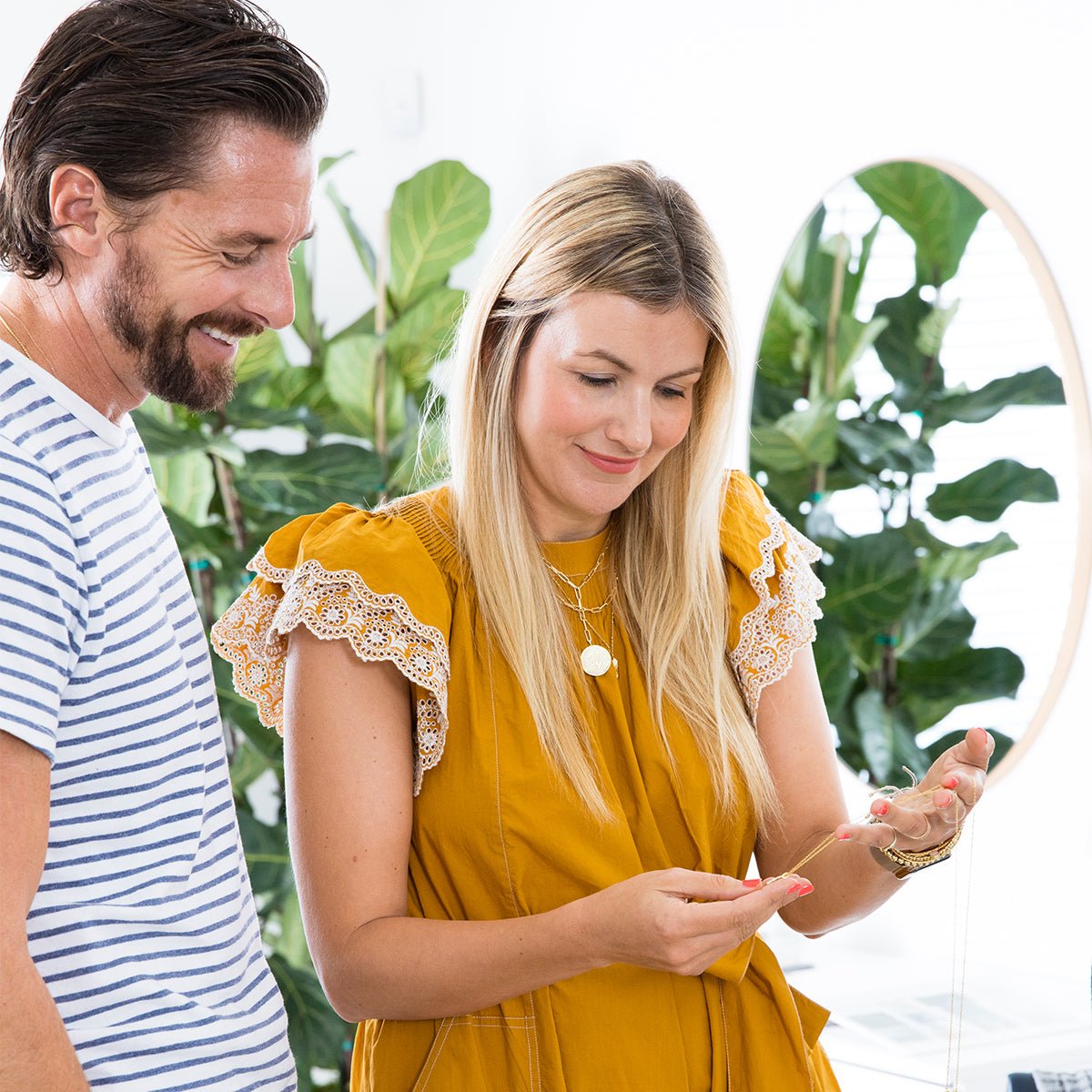 Co founders Gorjana and Jason Reidel looking at gorjana necklaces. 